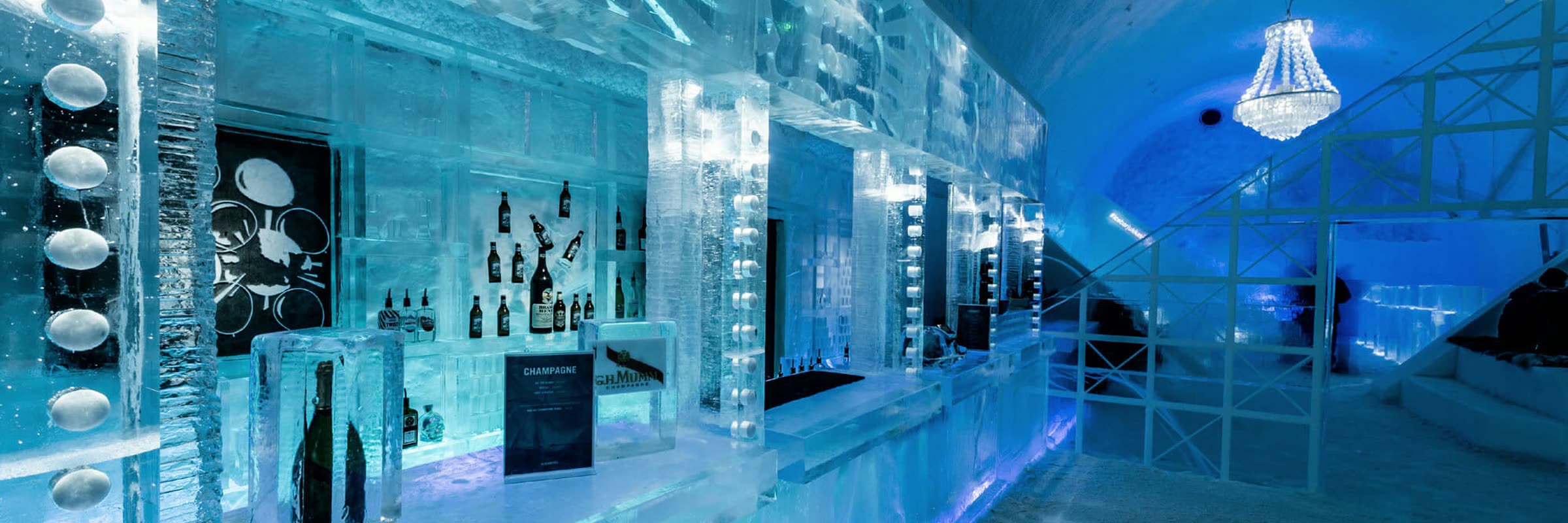 An ice bar counter and vaulted snow hall lit from within